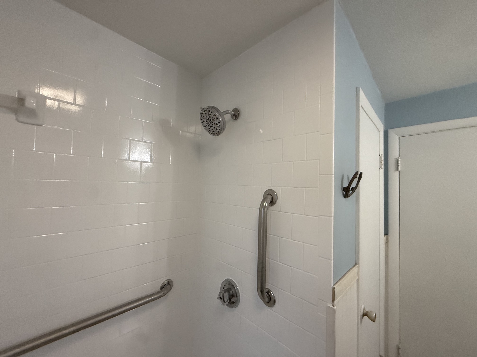 Freshly refinished bathtub and shower surround, glossy white finish
